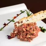 Steak tartar de carne excelente y su aliño sugerente